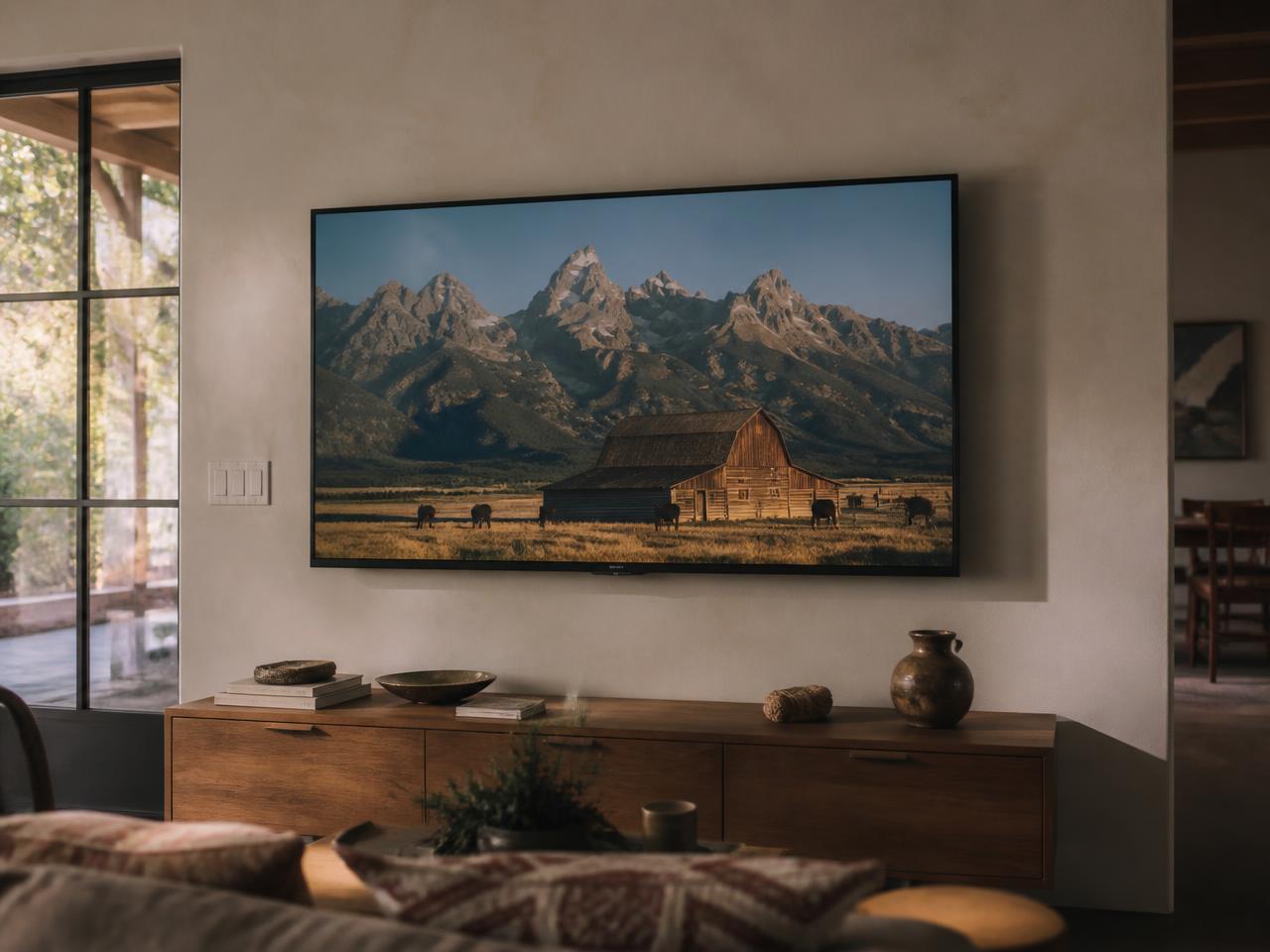 A wall-mounted television in a warm living room